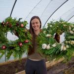 Emily Martin shows off two wreaths made from freshly foraged foliage with bits of dried flowers. (Photo by David Welton)