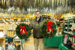 Photo by Luisa Loi
Isaiah Rawl, greens manager at A Knot in Thyme, poses with some freshly made wreaths inside of the gift shop.