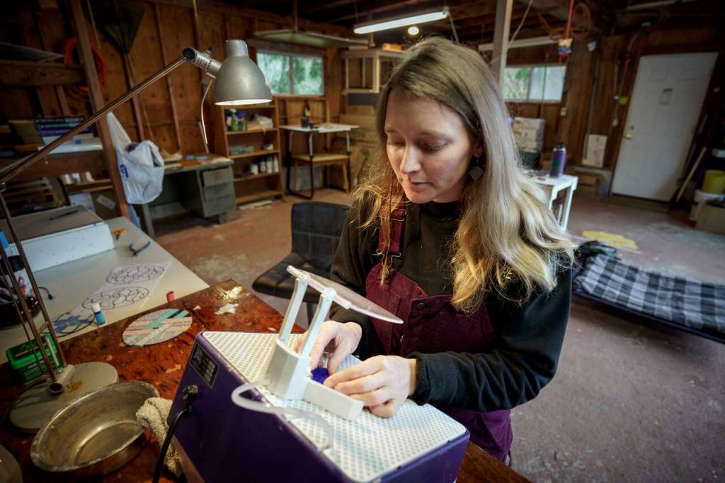 Bennett grinds a piece of stained glass. (Photo by David Welton)
