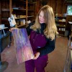 Bennett holds up a pane of iridescent purple glass. (Photo by David Welton)