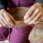 Bennett weaves together pine needles to create a basket, a process which takes several hours. (Photo by David Welton)