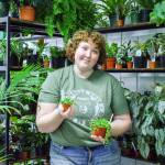 Tanzi Blackmer holds some plants. Tanzi, who is only 23, owns and runs the store with her mother. (Photo by Luisa Loi)