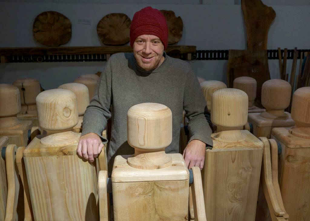 Woodworker Kelly Cameron stands amongst his army of peg people. (Photo by David Welton)