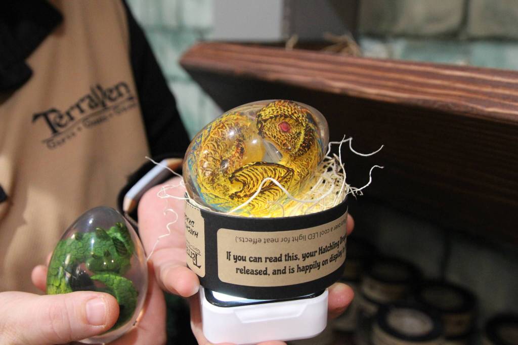 Kristi Uhles from TerraVen holds a hand-painted dragon in a clear resin egg. The egg can be placed on top of a light for an ethereal effect. (Photo by Luisa Loi)