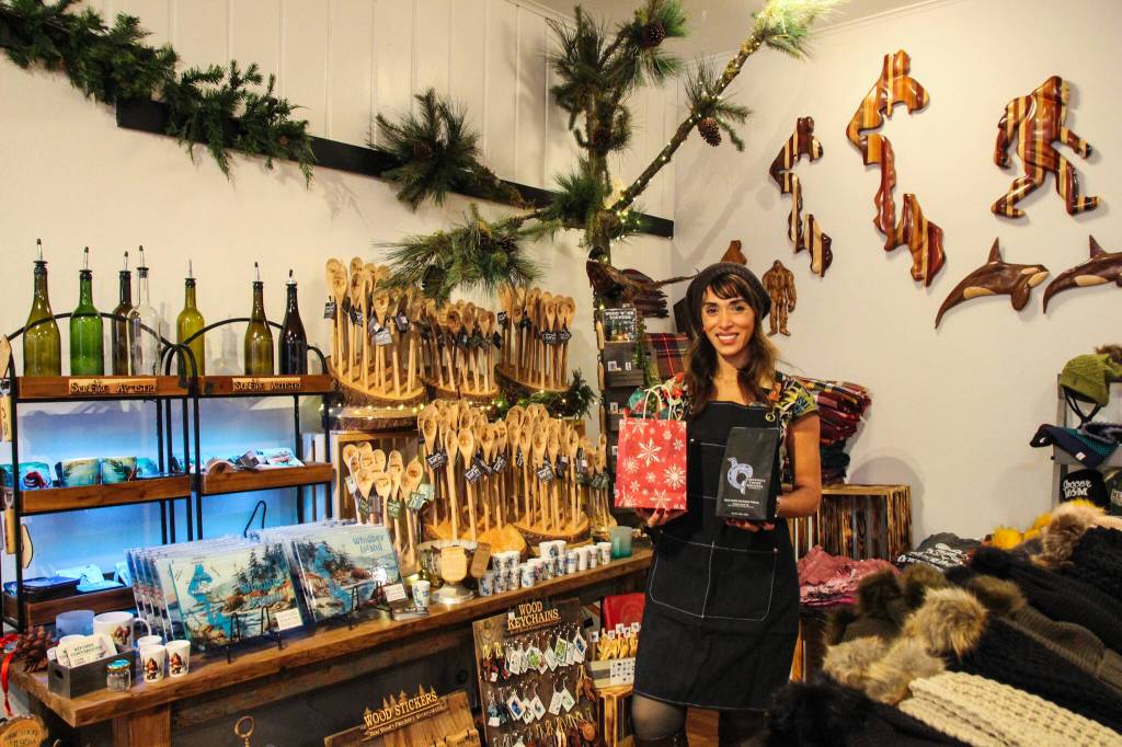 Juliana Uluave-Gould, owner of PNW Vibes, holds Coupeville Coffee Roasters Rustic Pacific Northwest Blend while surrounded by the art provided by her store. (Photo by Luisa Loi)