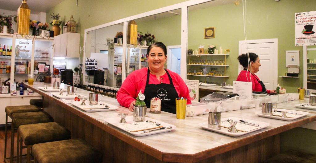 Megan Varner-Duckett, owner of Varner Candle Company, stands behind the bar where guests can enjoy a drink and craft their own candles. (Photo by Luisa Loi)