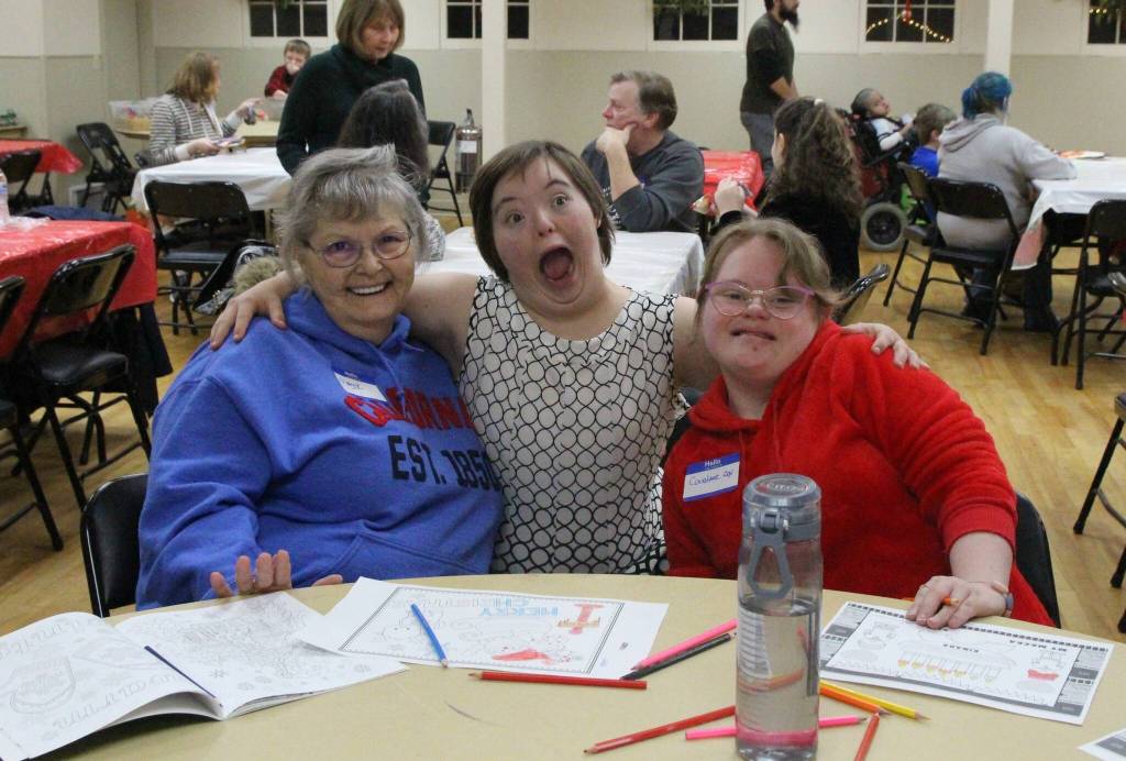 Left to right, Maggie Fairchild, Zoe Thompson and Courtney Cox take a break from crafting to pose for a photo. Later, Courtney surprised Santa with a bag of chips to thank him for his service. (Photo by Luisa Loi)