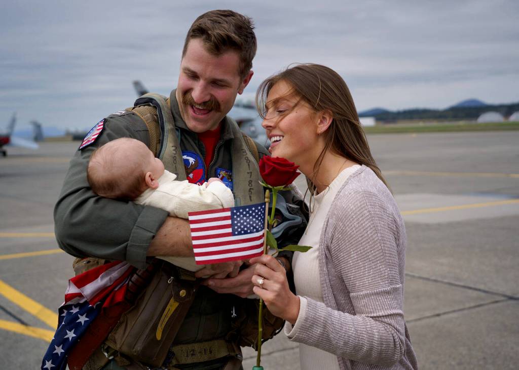 Scott Waitley greets his wife, Maggie, and 2-month-old son, Warren, after returning home from deployment in April. (Photo by David Welton)