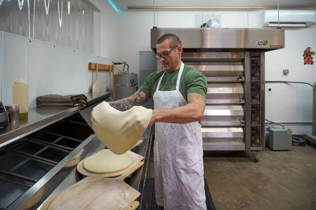 Paul stretches the pizza dough. (Photo by David Welton)