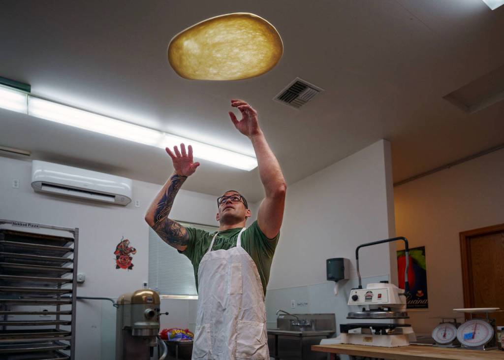 Paul throws some pizza dough up in the air. (Photo by David Welton)