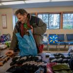Jon Kosa stopped by Island Church to try on a pair of shoes. He lives in a nearby encampment with eight others, who preferred to stay away, and he gathered supplies to bring back to them. (Photo by David Welton)