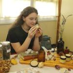 Tenth grader Alicia Jenkins smells some lemon balm lip balm she made. (Photo by Kira Erickson/South Whidbey Record)