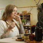 Woodhaven High School teacher Jules LeDrew samples some lemon balm lip balm made by a student. (Photo by Kira Erickson/South Whidbey Record)