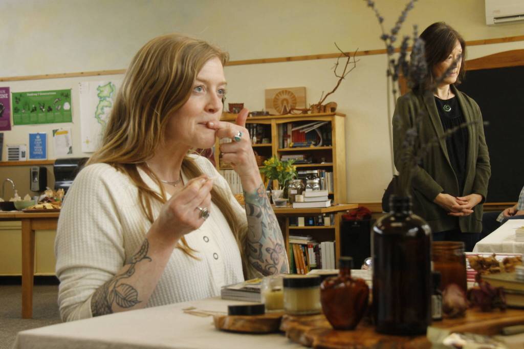 Woodhaven High School teacher Jules LeDrew samples some lemon balm lip balm made by a student. (Photo by Kira Erickson/South Whidbey Record)