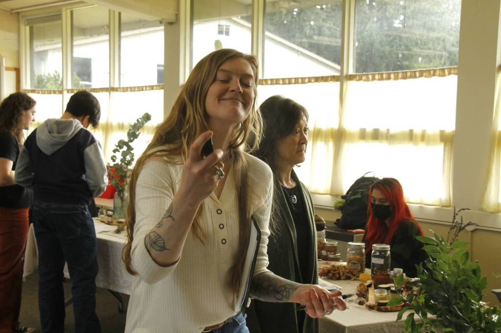 Woodhaven High School teacher Jules LeDrew tries a spray made by a student. (Photo by Kira Erickson/South Whidbey Record)