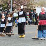 People in Dutch costumes walk in parade.