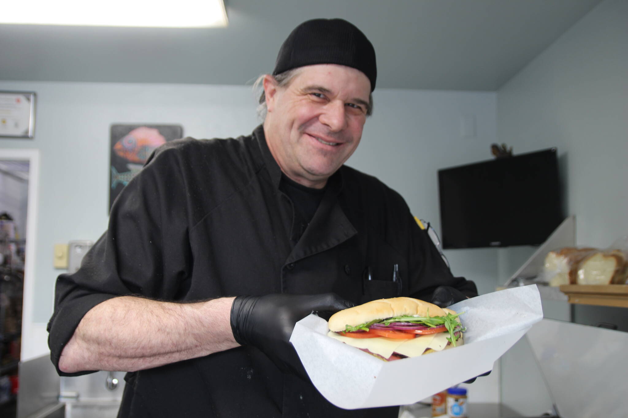Steve Clarke holds the Pastrami Sammie inside his store, Slab City Sammies. Without stoves or a fryer, the shop offers meals to drivers with a big appetite.	(Photo by Luisa Loi)