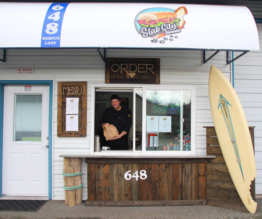 Steve Clarke hands out an order at his new sandwich shop, Slab City Sammies, which he opened after two years of hard work with his with his wife Jean Hamer. (Photo by Luisa Loi)