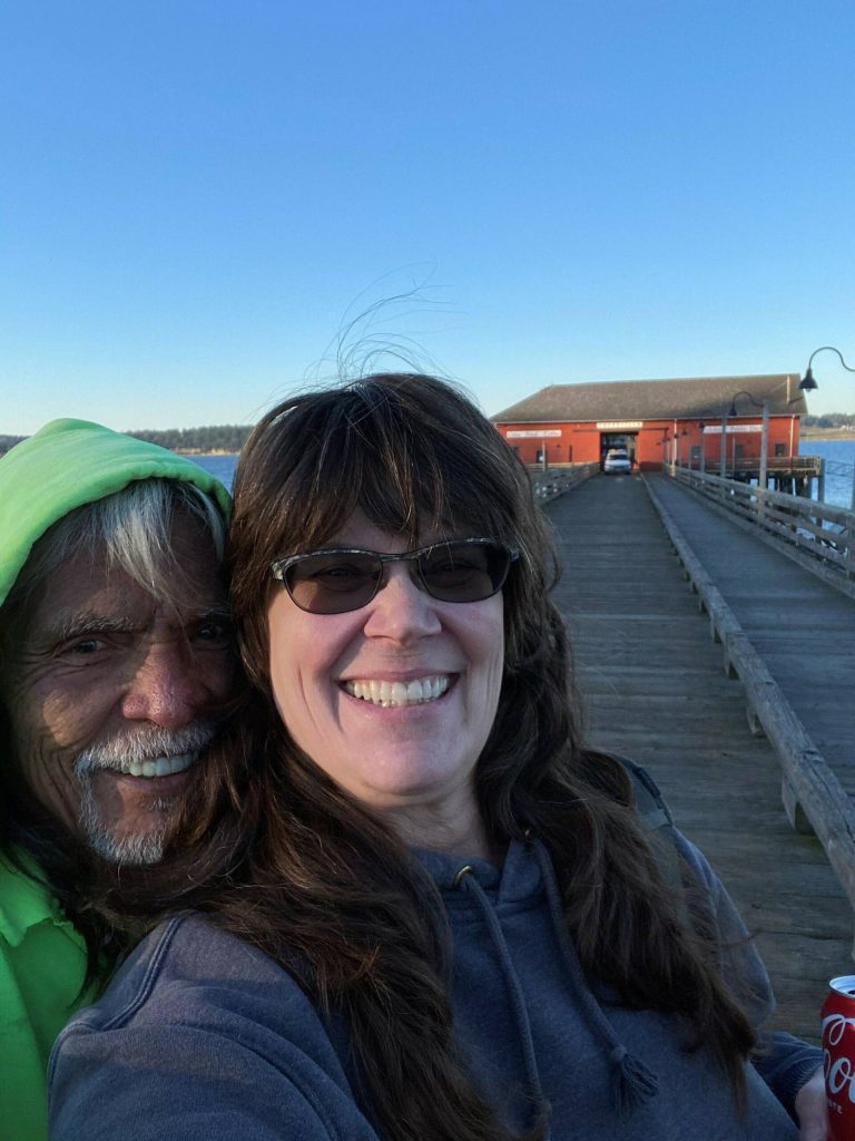 Tony Cladoosby and Michelle Calvin smile in front of the historic Coupeville Wharf, home to their newest coffee shop location. (Photo by Michelle Calvin)