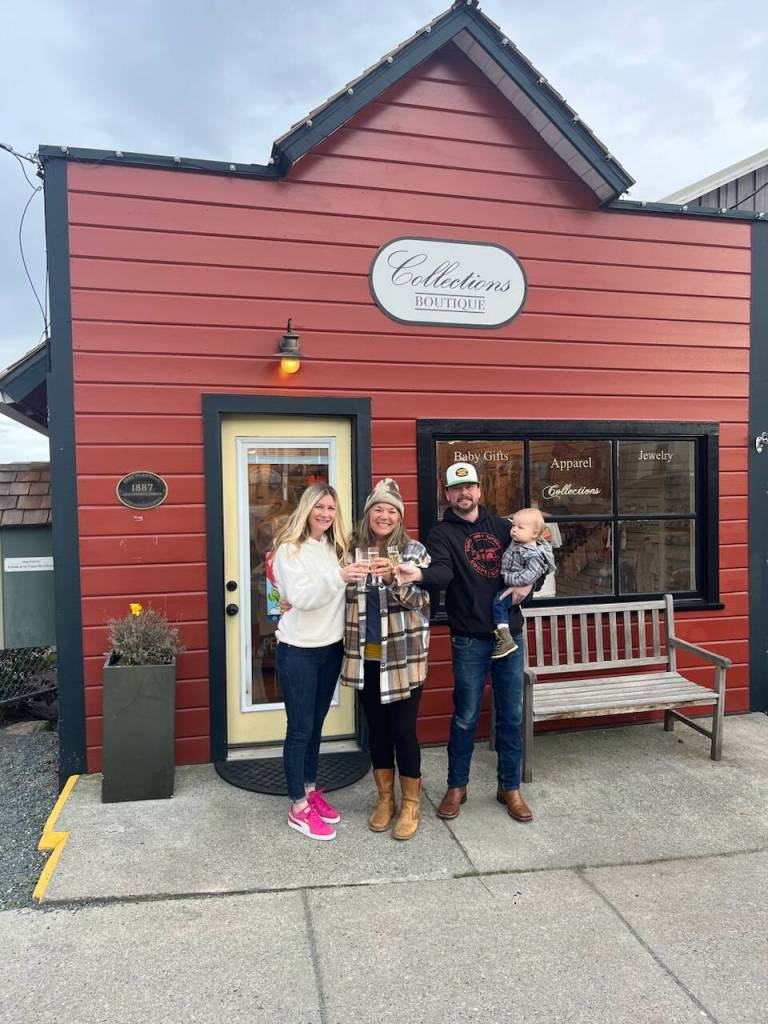From left, Collections Boutique Owner Jen Bachmann, Danielle Magnuson, Kyle Magnuson and baby Oscar Magnuson celebrate after the Magnusons signed the lease for the building that will house their new business, Wharf Dog Paddle and Pantry. (Photo provided)