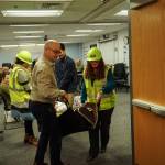 Island County Planning Manager Michael Jones, at left, Health Director Shawn Morris (back) and Board Clerk Jennifer Roll, at right, carry an actor during an earthquake demonstration at the commissioners meeting on Wednesday. (Photo by Sam Fletcher)