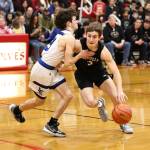 Photo by John Fisken
Logan Downes fights through a pesky defender on his way to collecting two of his game-high 28 points.