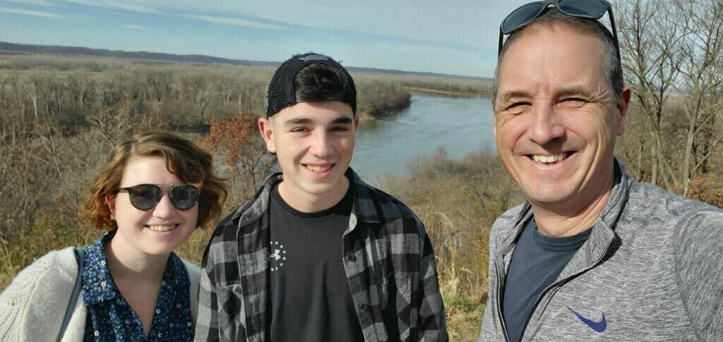 Donovan Davis, the CH-53E helicopter crew chief, smiles with his sister, Madison (left), and father, Greg (right). (Photo courtesy of Greg Davis)