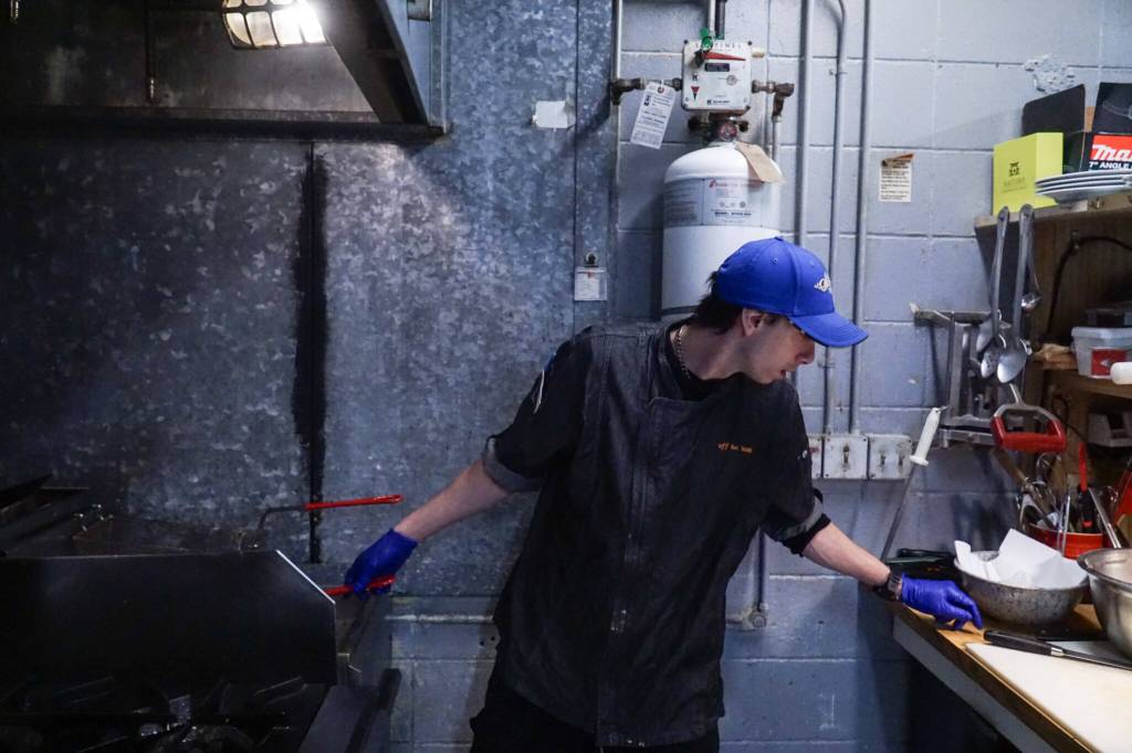 Joshua Michael, Off the Hook sous chef, works in the kitchen Friday. (Photo by Sam Fletcher)
