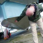 Andrew Cummings, PNW Naval Air Museum aircraft conservation and restoration lead, identifies punctures in the PBY that need to be repaired. (Photo by Sam Fletcher)