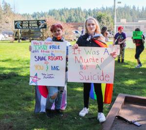 Photo by Luisa Loi
Aryn States, at left, and Leilani Floyd pose with signs at the walkout in honor of Nex Benedict. The two South Whidbey High School students organized the protest on March 18 to demand a safer environment for LGBTQ+ people.
