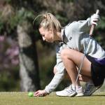 Oak Harbor girls golfer Annalise Wesley checks her ball during the Whidbey Shootout March 18. (Photo by John Fisken)