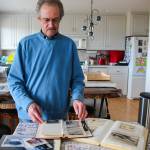 Donald Kaiser, a veteran, looks through photos from the Vietnam War. To this day, he keeps an extensive collection of photos, newspaper cut-outs and diary entries he collected and wrote while he was in charge of a crew of five men on board a swiftboat. (Photo by Luisa Loi)