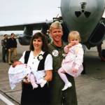 Sherri Pierson, left, holds her daughter Alyssa, and Randy Pierson holds his daughter Brooke during the VAQ-137 Rooks Homecoming.