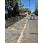 The Front Street boardwalk, which is made of wooden boards, is unsafe in its current state. Mayor Molly Hughes and Public Works Director Joe Grogan believe the safest alternative would be concrete boards that look like wood, as seen in these three renderings. From left, a white picket fence, a wood mesh fence and a cedar fence add protection. (Photos provided)