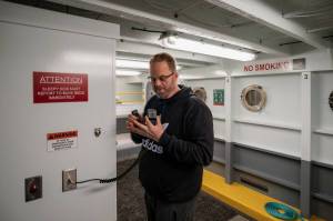 Ferry Cove host Ryan Anderson makes an announcement on the ferry radio in the basement. (Photo by David Welton)