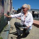 Paula Fries finishes her Serendipity Lane mural on Thursday. (Photo by Sam Fletcher)