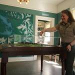 Interpretive specialist Jen Gray interacts with a Fort Casey map in the new Admiralty Head Lighthouse exhibit. (Photo by Sam Fletcher)