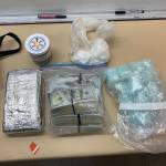 An Oak Harbor police photo shows plastic bags of suspected cocaine, a foil-covered brick of suspected cocaine, $79,000 in cash and large number blue M30 pills.