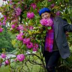Greenbank resident Kristi ODonnell admires a patch of rhododendrons at the side of Highway 525 that she helped save nearly 20 years ago. (Photo by David Welton)
