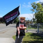 Photo by Luisa Loi
Pam Fick holds a flag and wears a Handmaids Tale shirt. The Handmaids Tale is the story about a society were women are completely subservient to men and have no reproductive freedoms, which Fick believes could become a reality.