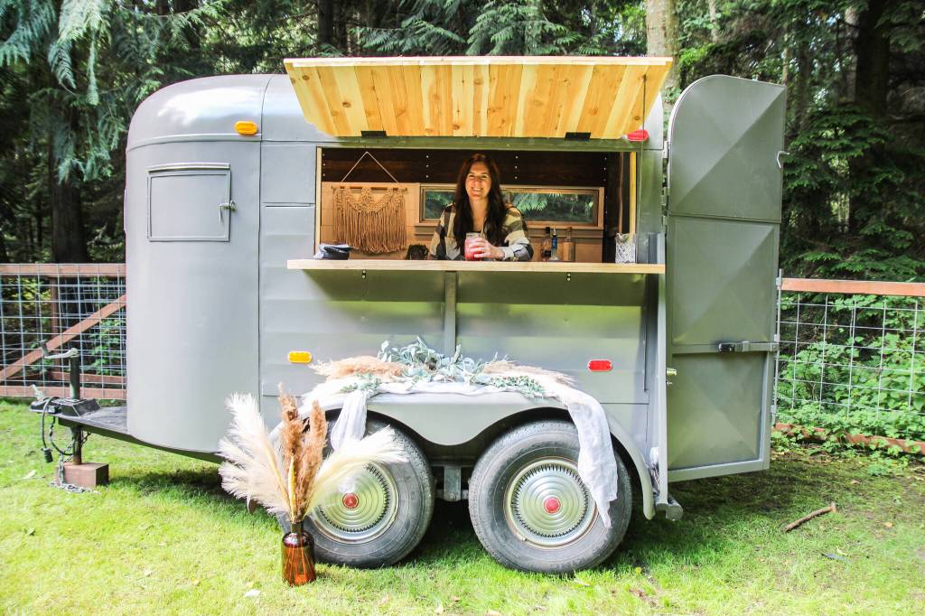 Shaylene Roemer serves a Black Current Lemonade inside the mobile bar, which until three months prior was a horse trailer. (Photo by Luisa Loi)