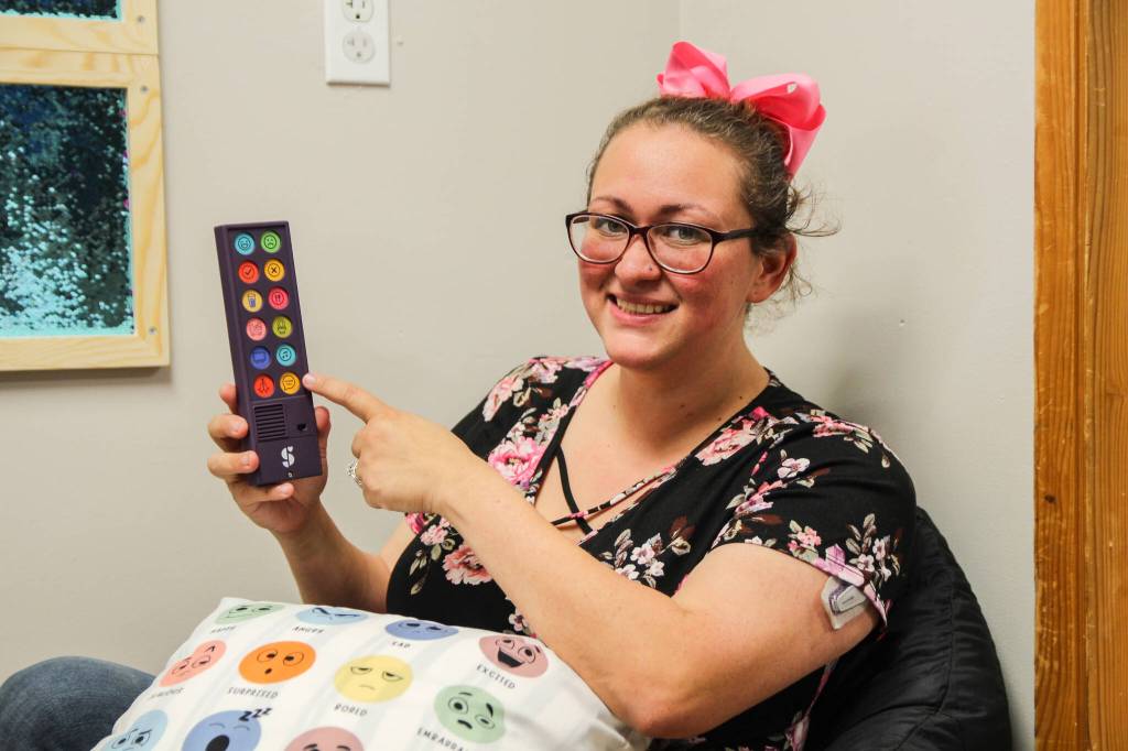 Jaylynn Sybrant holds a communication device for nonverbal children. (Photo by Luisa Loi)