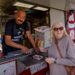Fried foods vendor Roberto Martinez hands Jo Ellen Margenau of Wisconsin her very first chunk of deep-fried butter. (Photo by David Welton)