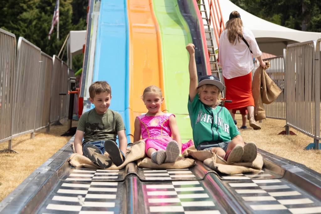 Kids race down the giant slide at the Whidbey Island Fair. (Photo by Caitlyn Anderson)