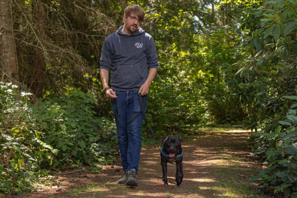 WAIF Community Outreach Coordinator Tré Frampton walks Tino the rescue dog outside the WAIF Ellery Cramer Family Animal Shelter, July 24. (Photo by Caitlyn Anderson)