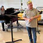 Eileen Soskin plays the piano while singer and actor Ken Merrell dresses up in costume during a rehearsal. (Photo provided)