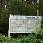 The Valley High Park sign stands in the bushes, July 30. (Photo by Caitlyn Anderson)