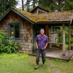 Land Steward Timothy Hull, son of founders Vivienne and Fritz Hull, stands before the small cabin where he spent his childhood summers. (Photo by David Welton)