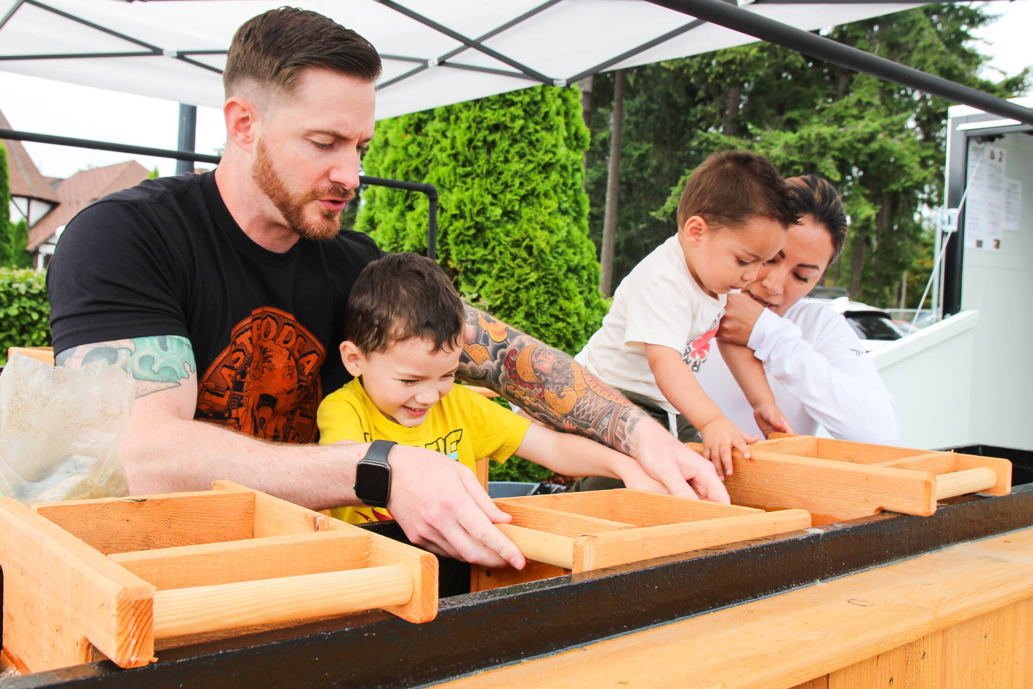 From left, Joe, Orion, Yessi and Jason Squish Dunegan sift sand in the sluice box to find hidden treasures. (Photo by Luisa Loi)
