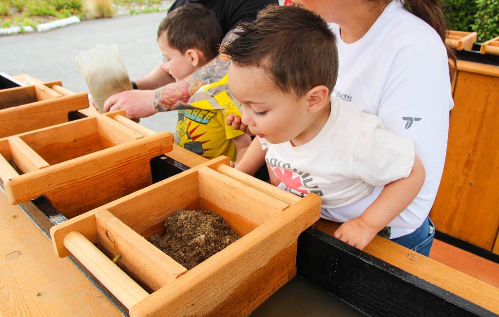Jason, 1, is excited to sift sand with his mother, Yessi. (Photo by Luisa Loi)